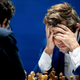 Magnus Carlsen hangs his head in his hands.